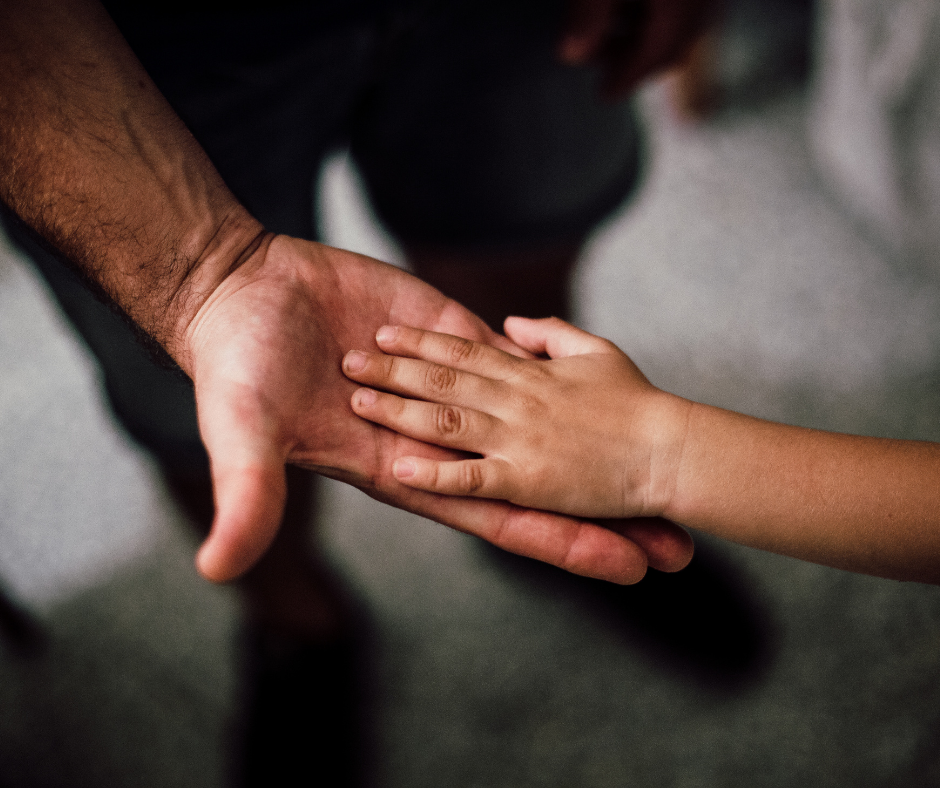 Child and adult holding hands