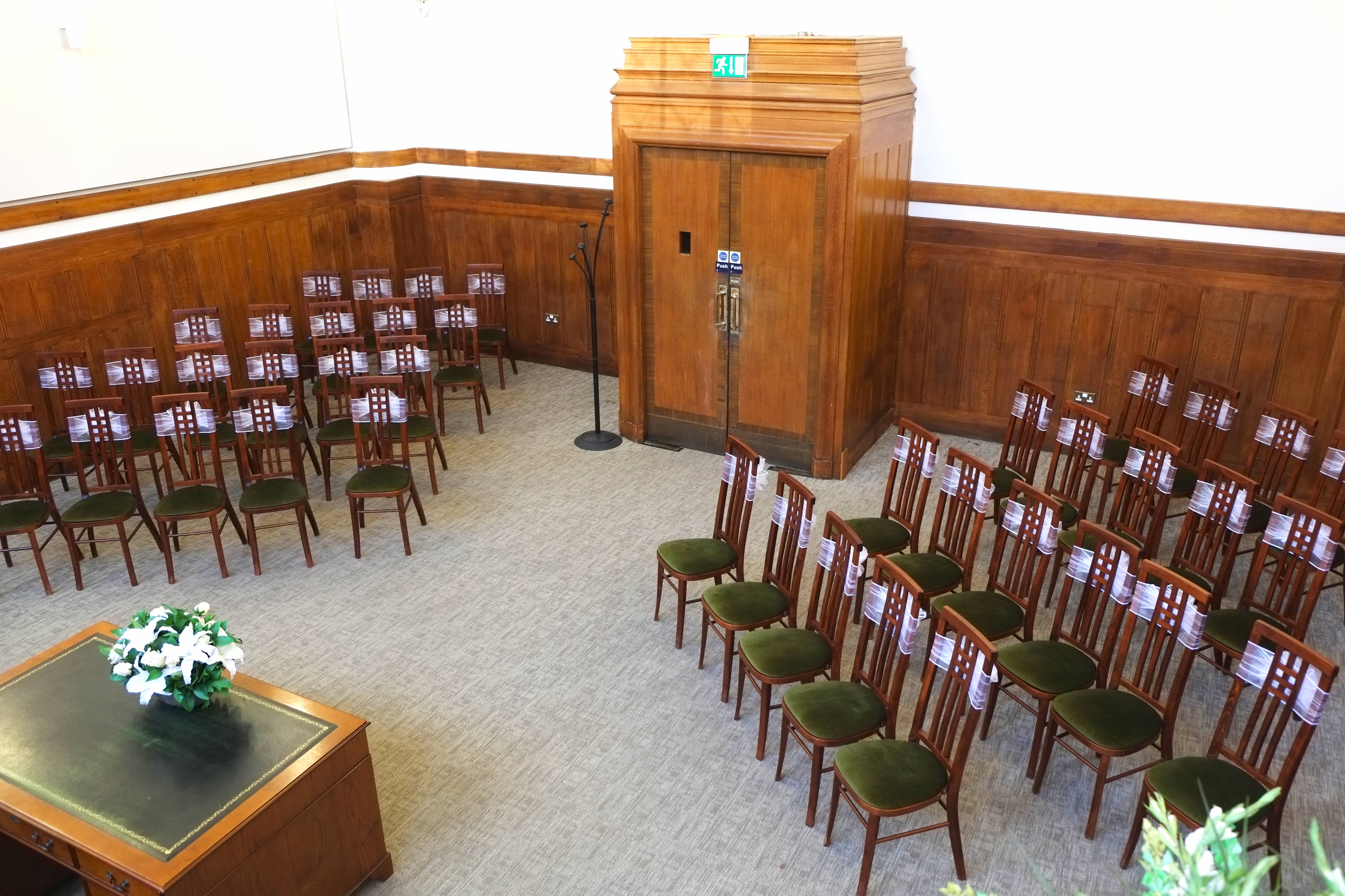 Room with grey carpet, and chairs laid out at an angle from the door.