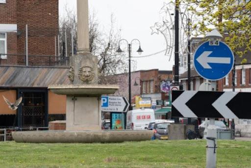 Image is a photograph taken of the Fountain Roundabout in New Malden