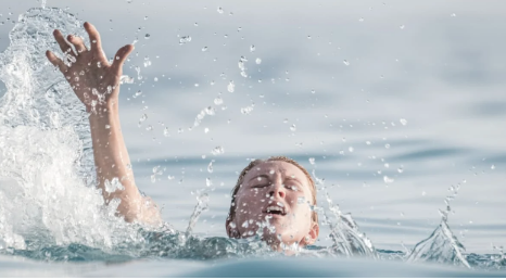 Girl drowning in the sea, arms waving in the air.