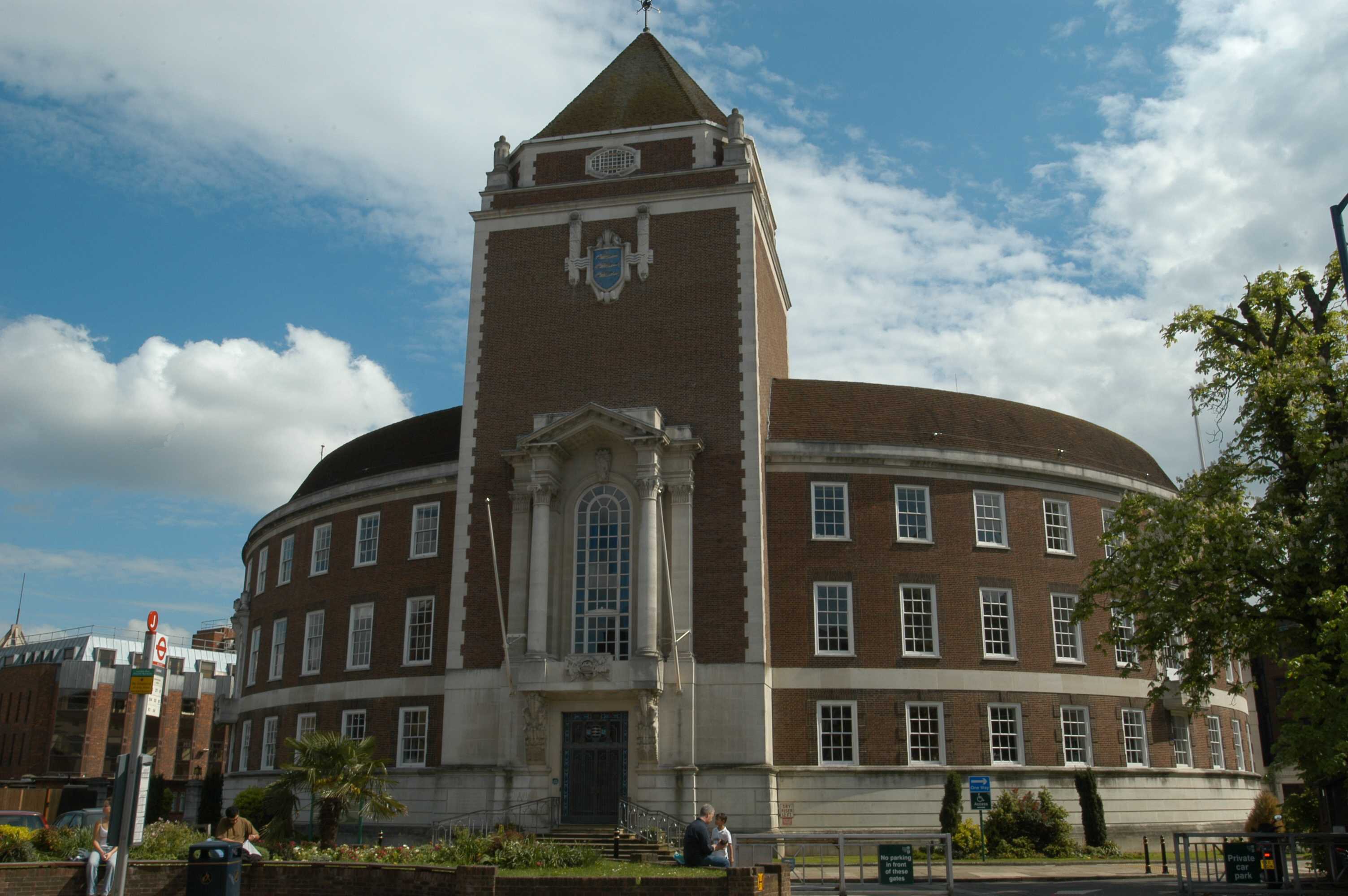 Image showing large, round, brown brick building with white stone entryway and glass front doors.