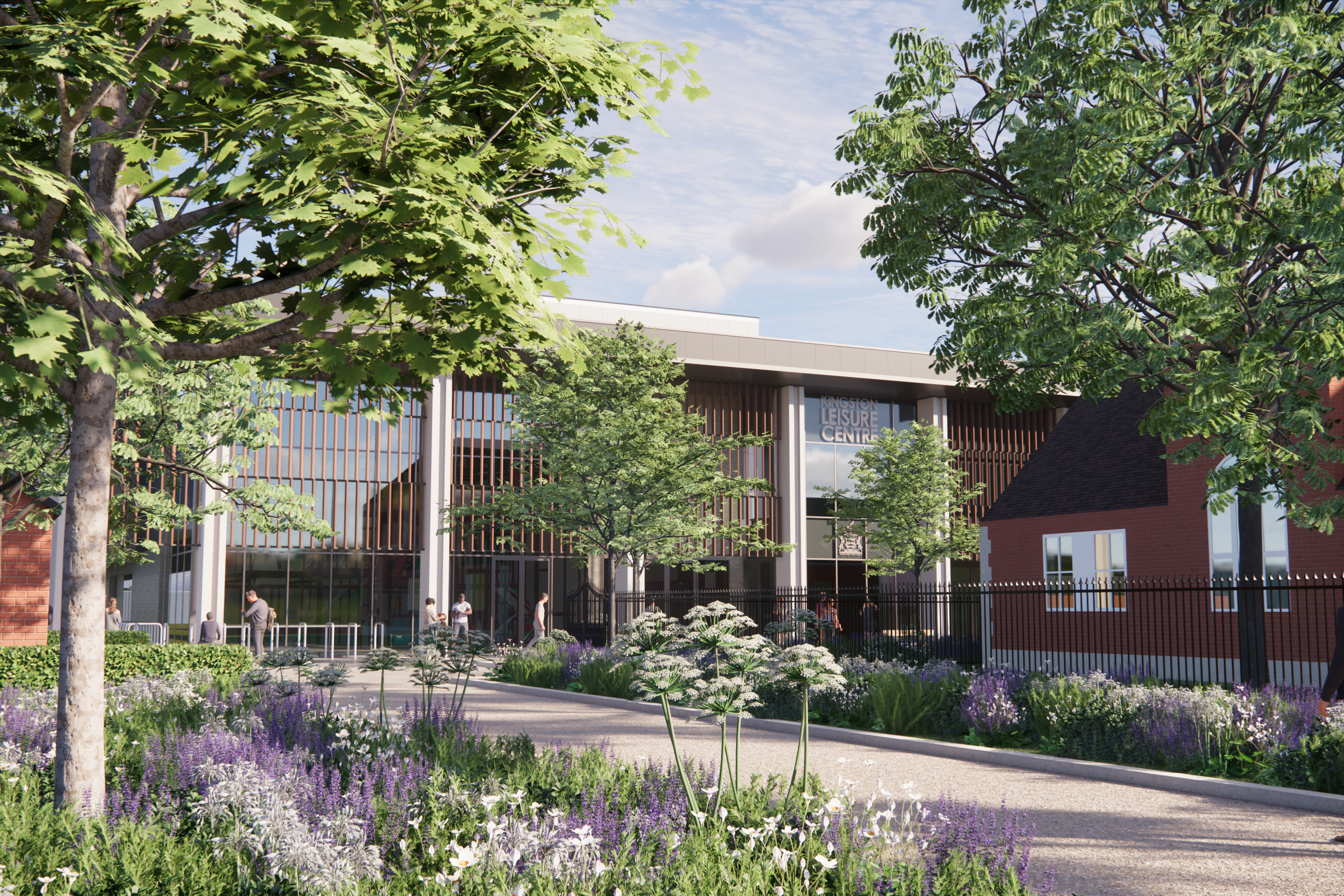 Image showing a wide pathway leading to a 2 storey building with planting and trees either side. The building has a glass front with small terracotta lines in front and grey columns.