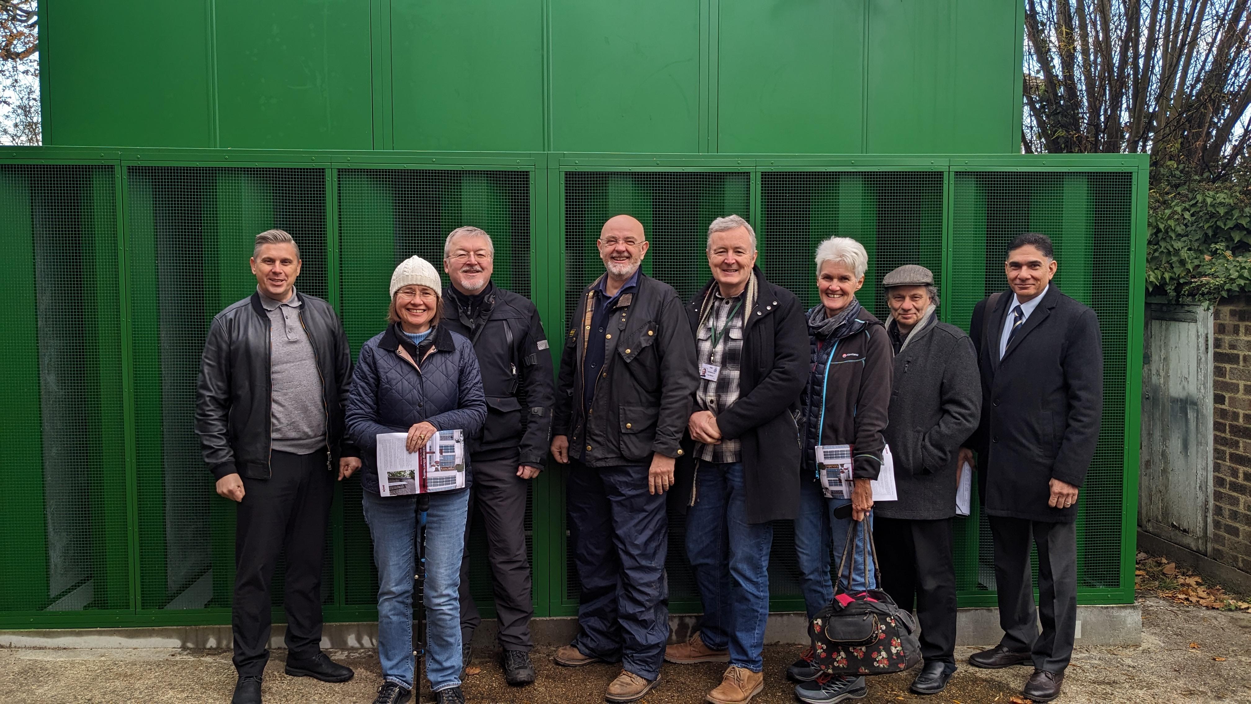 Councillors and officers stand with new heat pump at Four Oaks hostel.