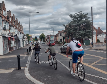 three people on bikes are cycling away from the camera on a segregated cycle route.