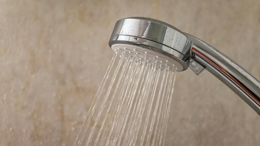 A silver showerhead spraying water
