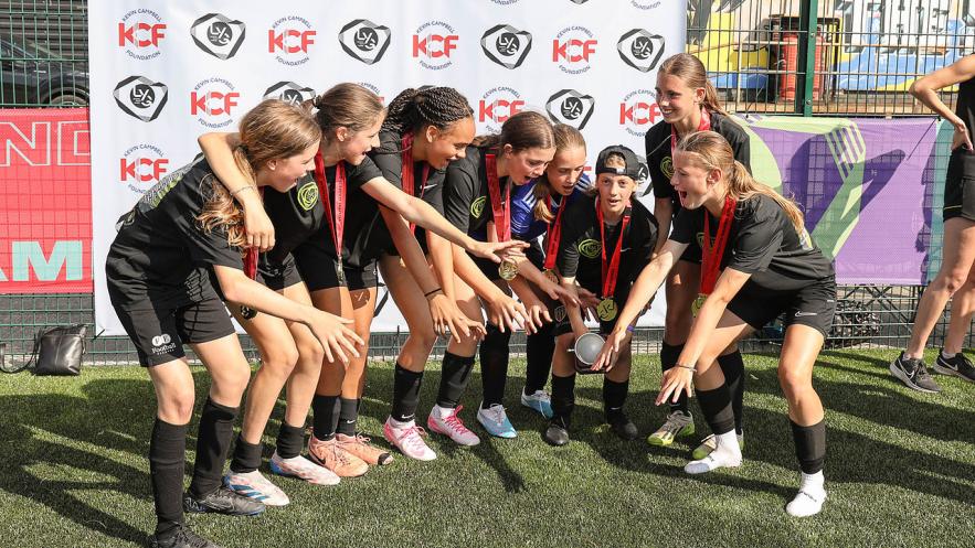 Kingston's Under 13s girls football squad, celebrating their achievement with medals around their neck.