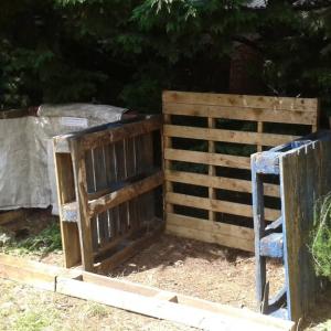 Wooden pallets which have been turned into a compost bins.